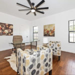 Furnished living room with patterned accent chairs and ceiling fan