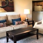 White sectional sofa and ottoman in a furnished high-rise apartment